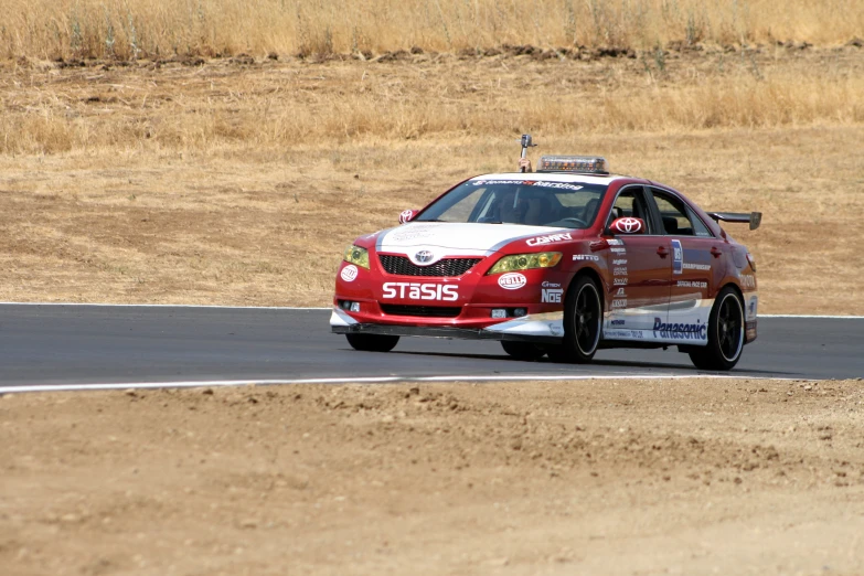 a car driving down the road on dirt