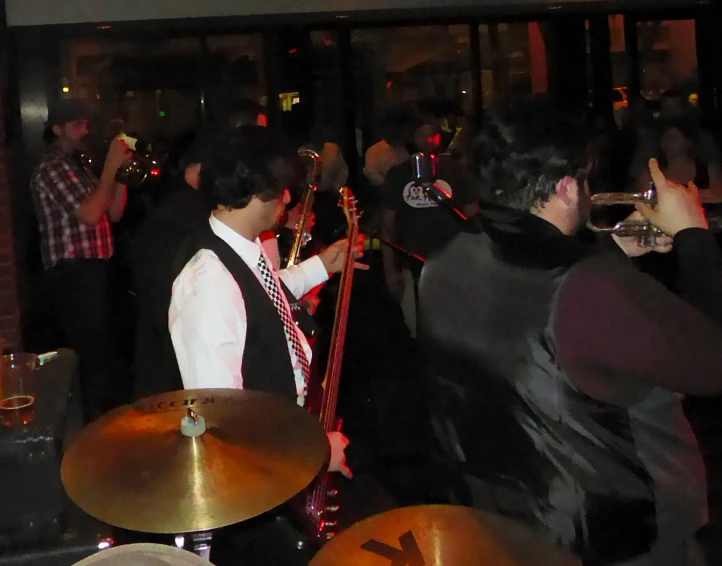 a group of people that are standing around a room with musical instruments