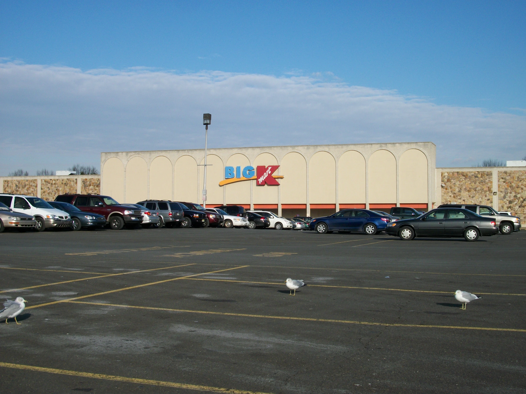 a large parking lot has parked cars in front