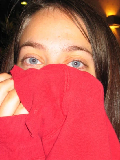 woman with red sweater covering face over her eyes