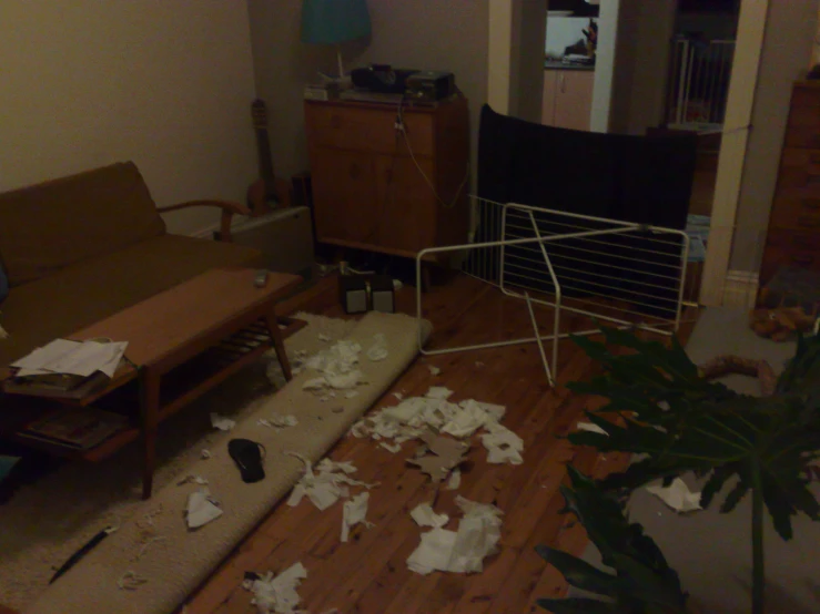 an image of a messy living room with wood flooring