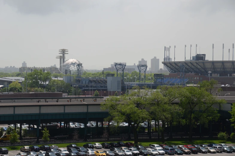 this city skyline features a stadium, a sports arena, and a parking lot