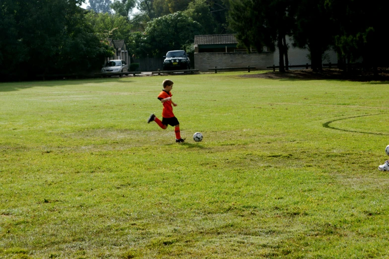 a young person kicking a soccer ball on a field