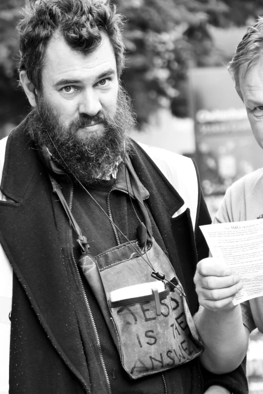 a man with a beard and mustache holding papers