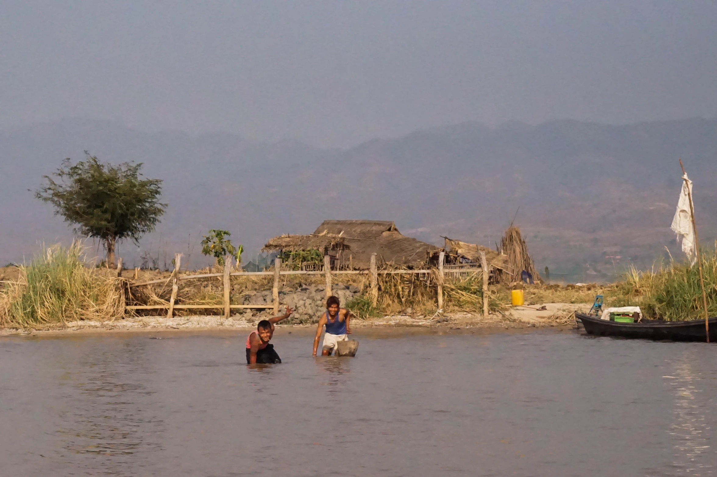 some people are swimming in the lake with boats