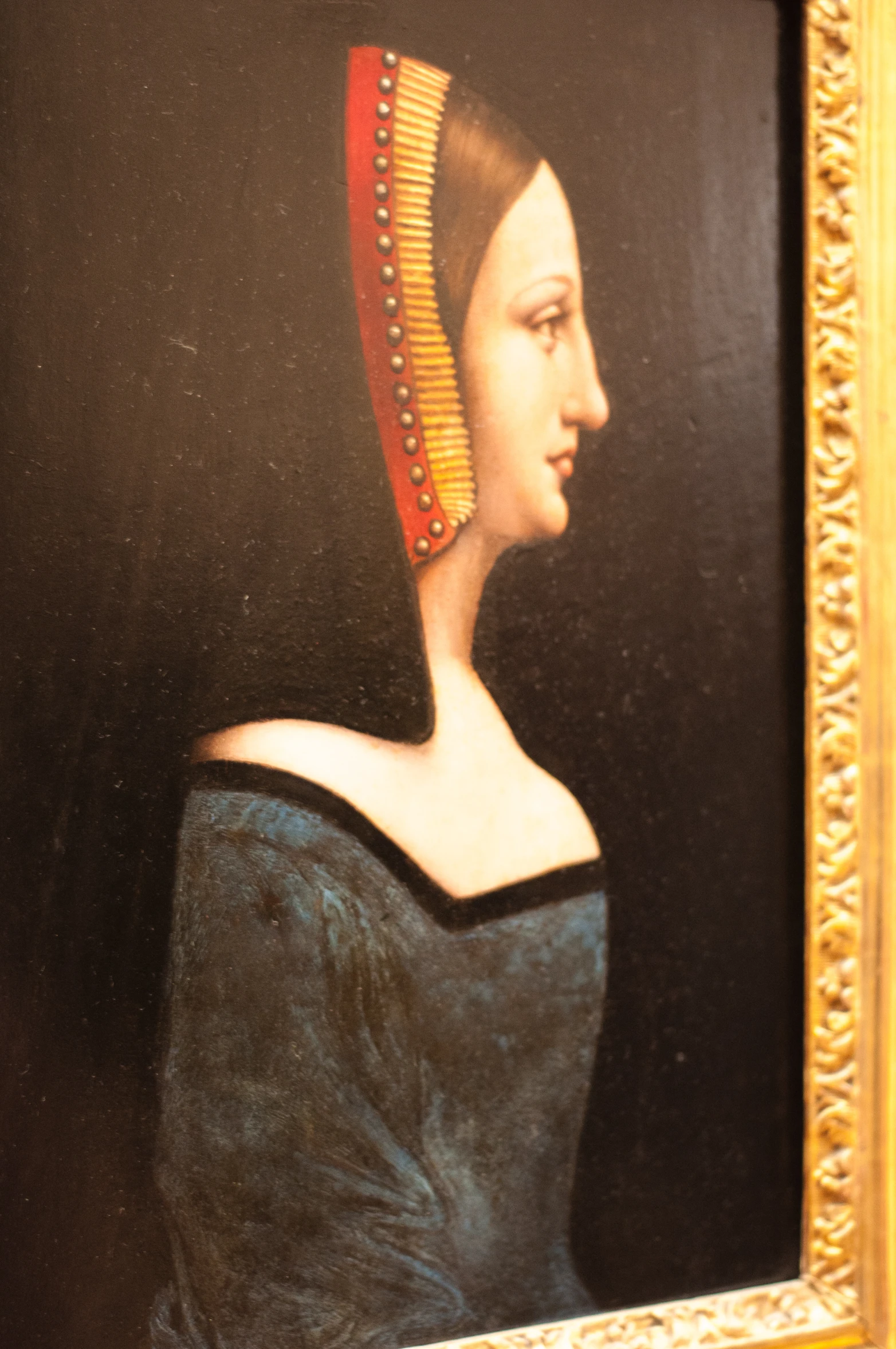 painting of woman in blue dress holding a fan looking back