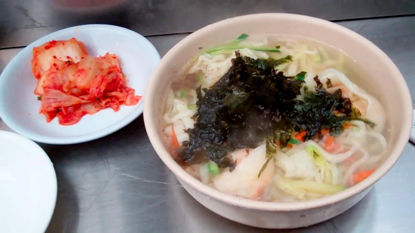 an asian soup with meat and vegetables is ready to be eaten