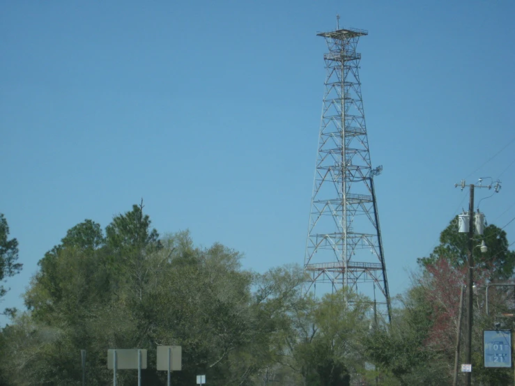 traffic and a tall metal tower next to trees