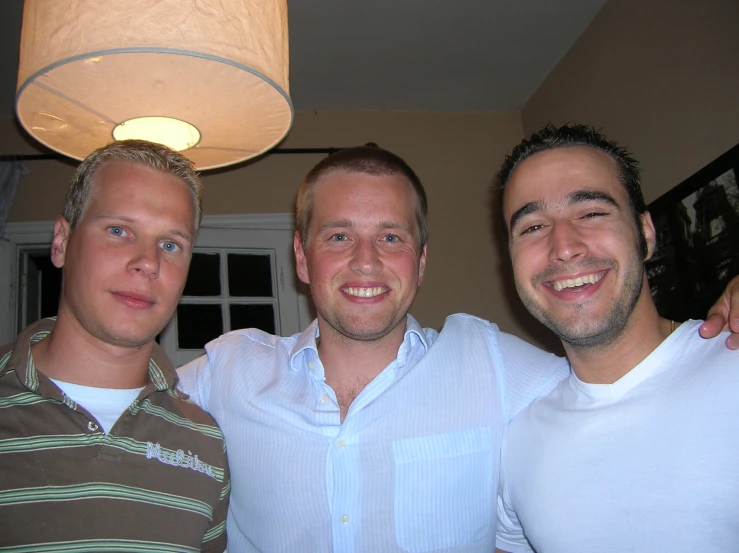 three men stand together in the living room smiling