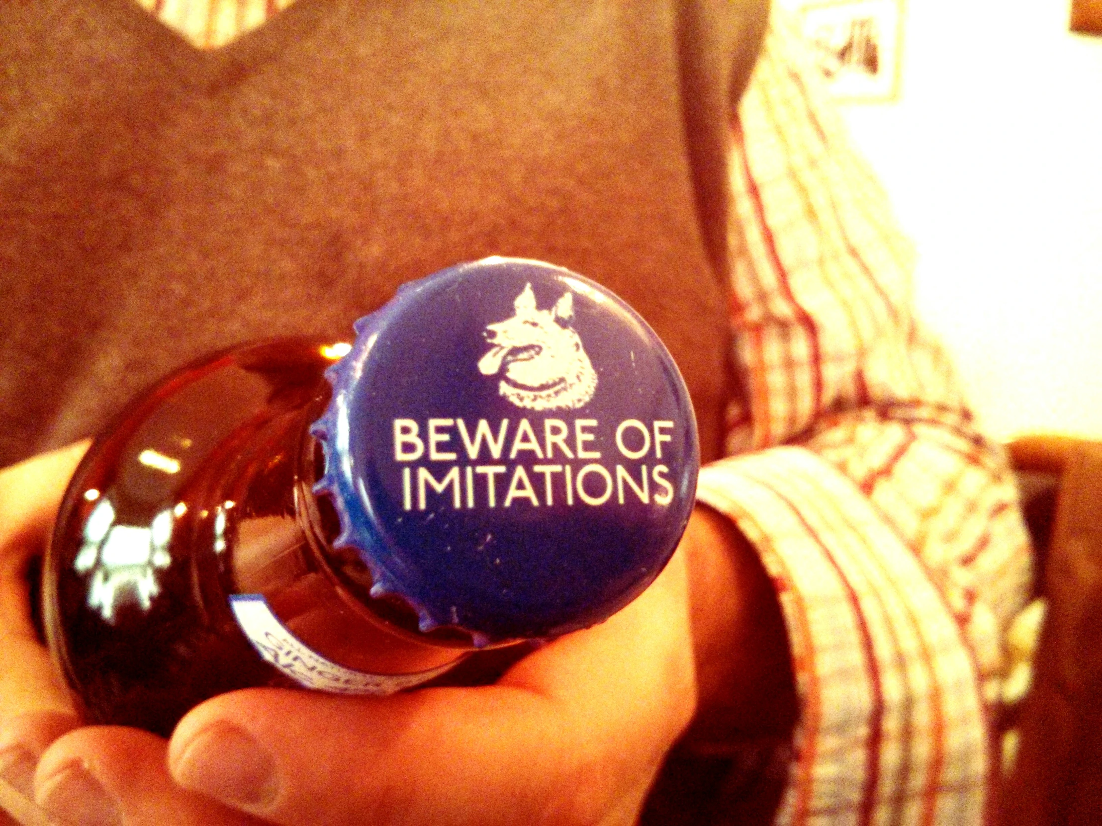 a person holding a small bottle with a badge on it