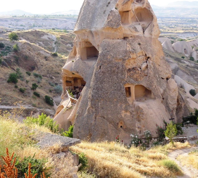 several rock structures in a field by some hills