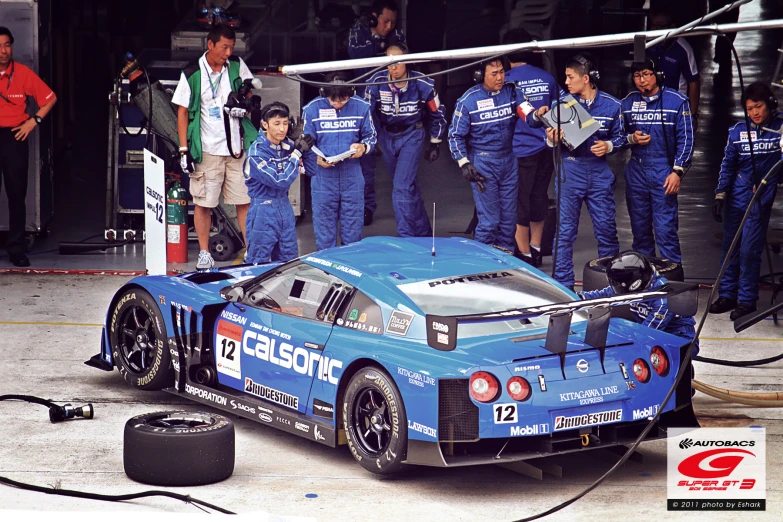 several race cars with people standing around