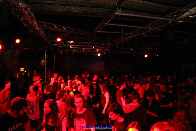 a large group of people dancing in a building at night