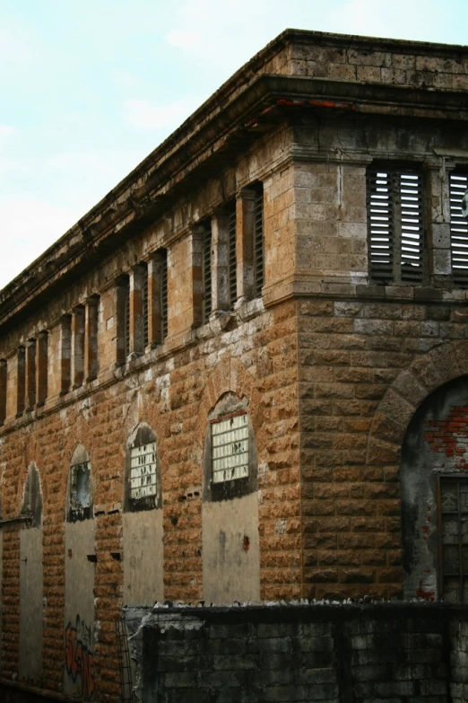 a brick building with windows and broken glass on the windows