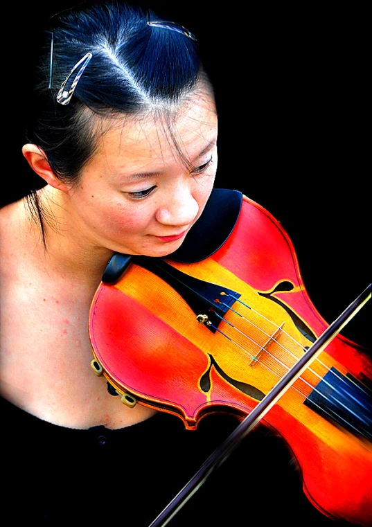 a woman is playing the violin while wearing a head band
