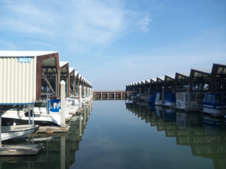 the dock has several boats at it and a building near them