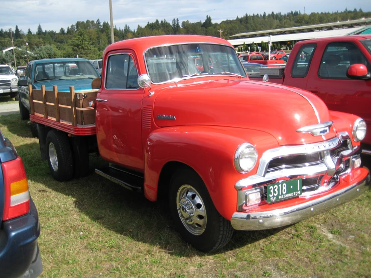 red pick up truck parked next to other vehicles