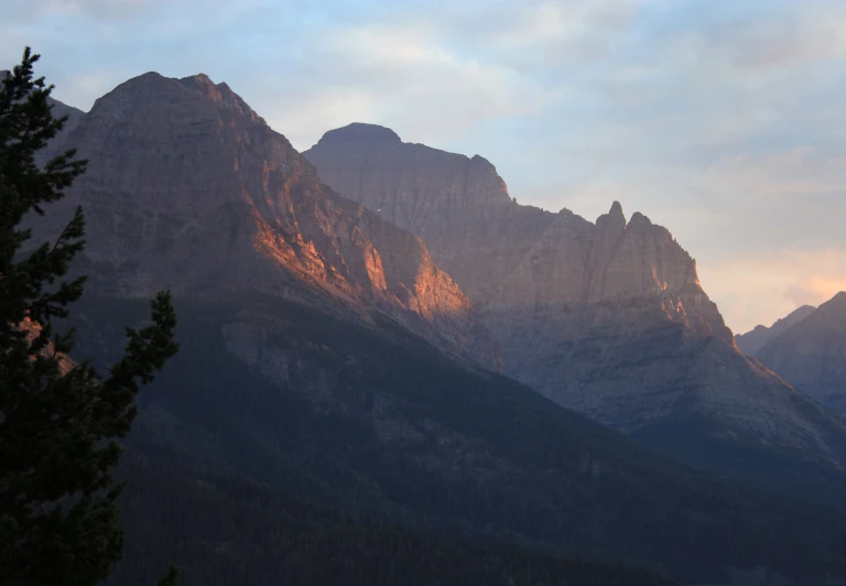 a mountain range that is very steep with some tall trees on one side