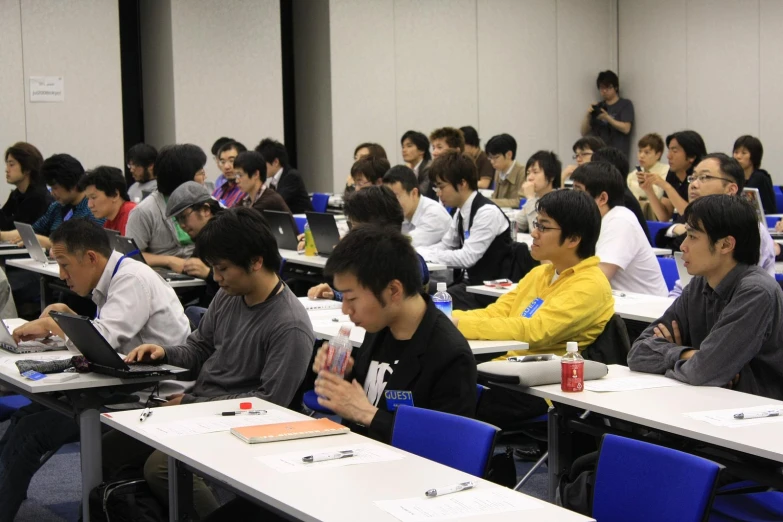 a large room with students working on their computers