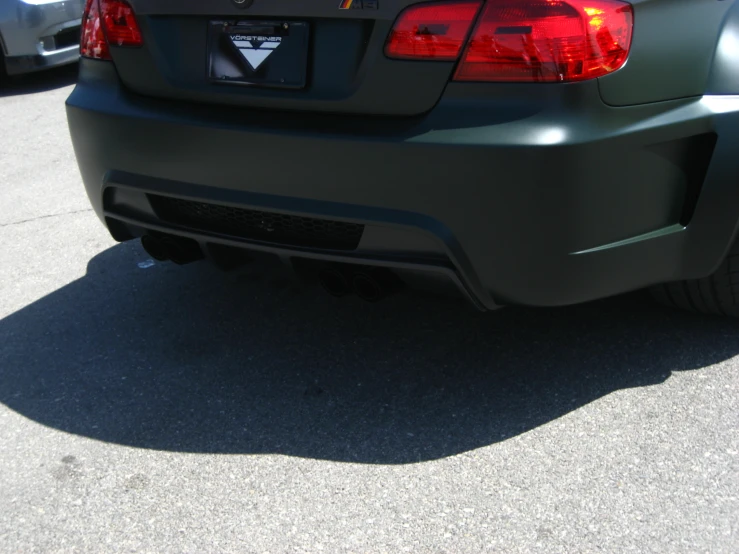 a small black car with some big exhaust pipes on the rear