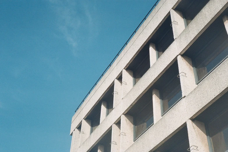 a concrete building under a blue sky and a stop sign