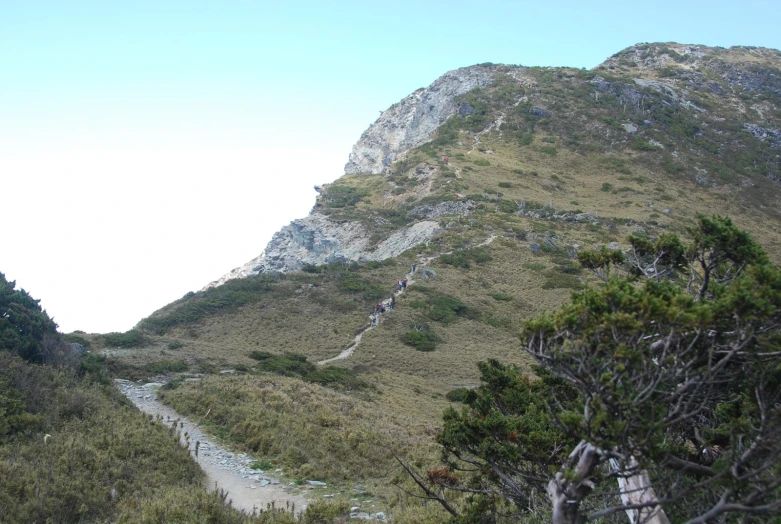 the view from below of a tall mountain with small pathway in between