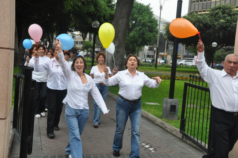 group of people on the street holding their hands up in front of them