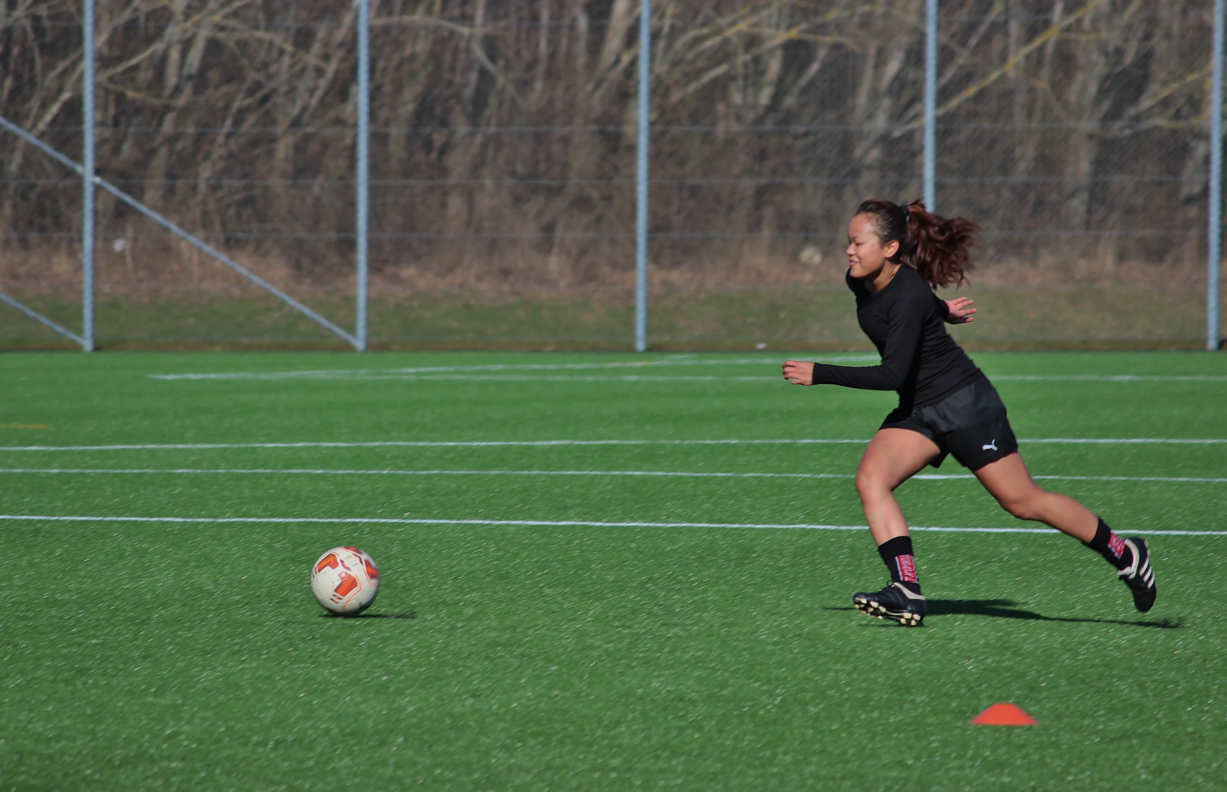 a woman is running after a soccer ball