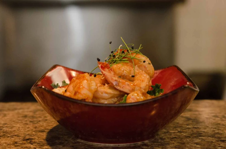 a bowl filled with shrimp and a garnished garnish on top of it