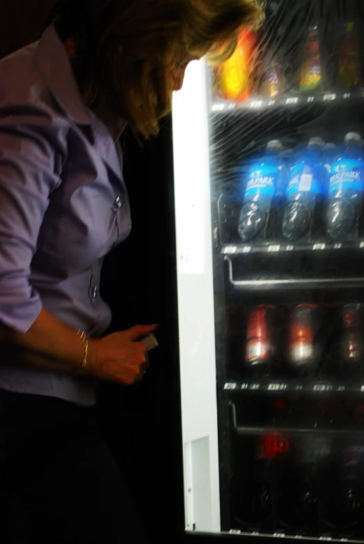 a woman checking out the door of a vending machine