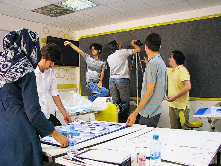 a group of people standing around an exhibition table