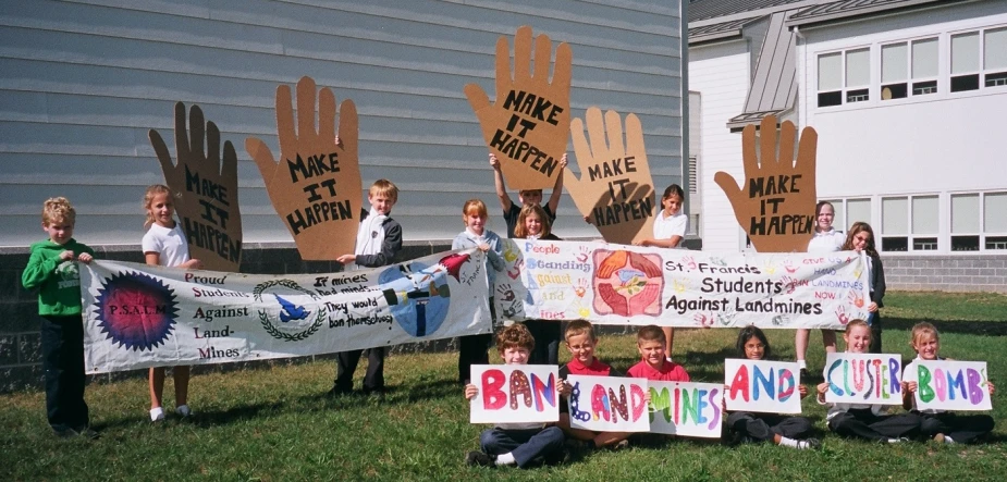 some children in front of some handprinted signs