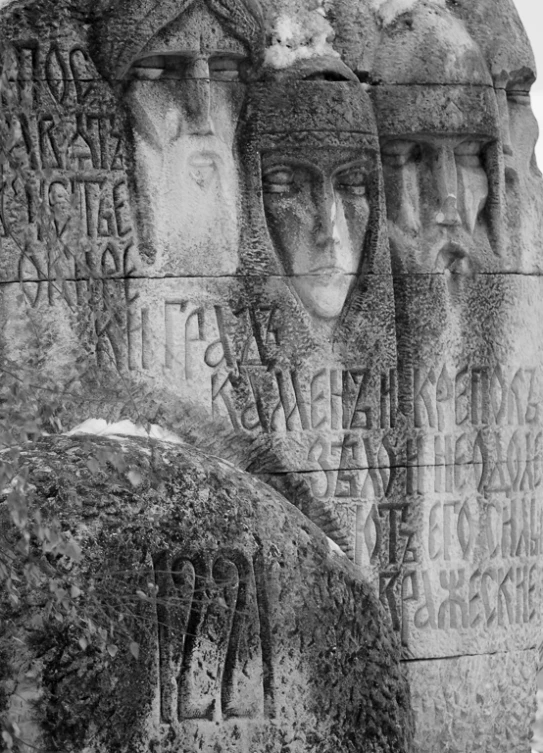 stone carvings with faces in various languages on them