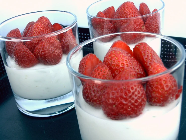 glass cups filled with strawberries on a tray