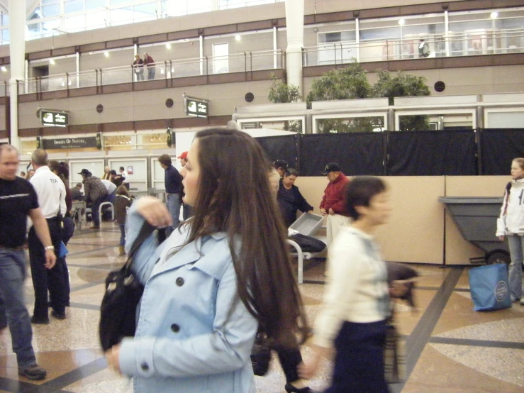 an indoor waiting area with people walking in it