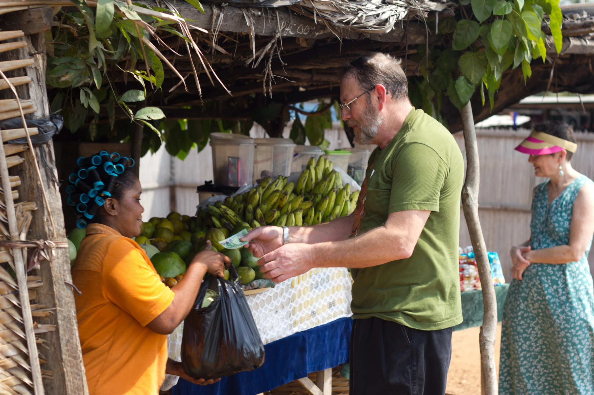 a man and woman picking up a bunch of bananas