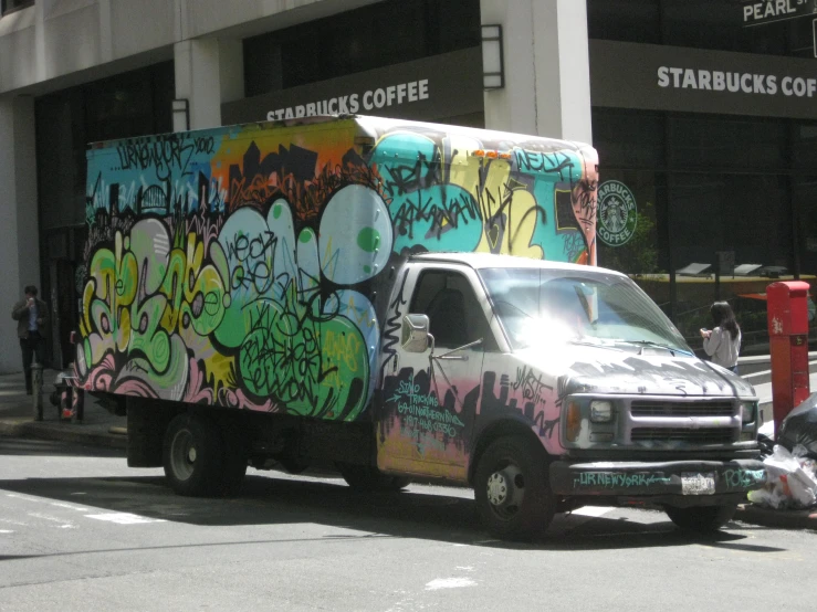 a truck with many different colors and graffiti on the side