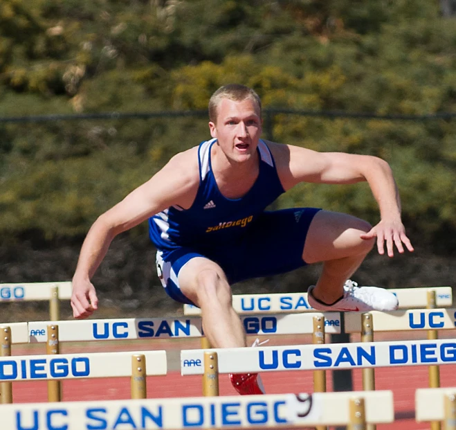 a male athlete in action on a hurdles