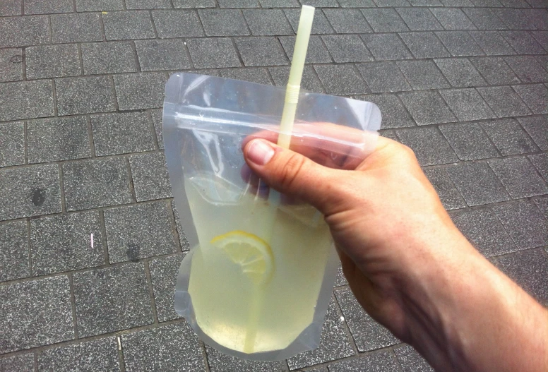 a person holding up a plastic drinking glass in the air