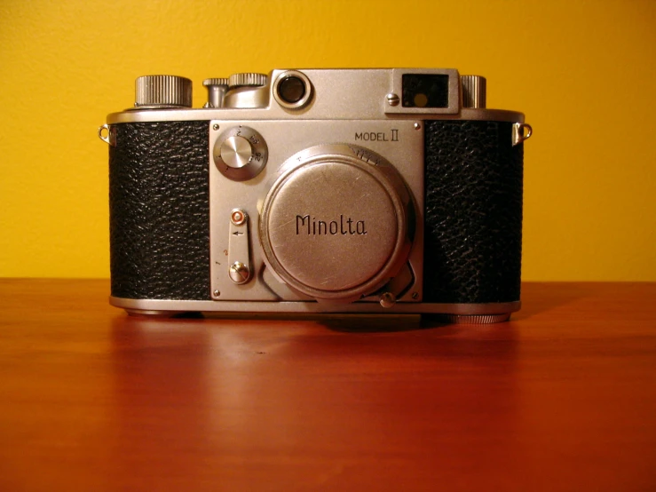 a vintage camera sits on a wooden table