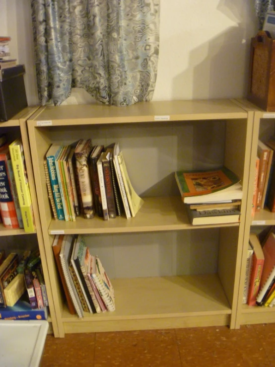 an open book shelf and two books are in the corner