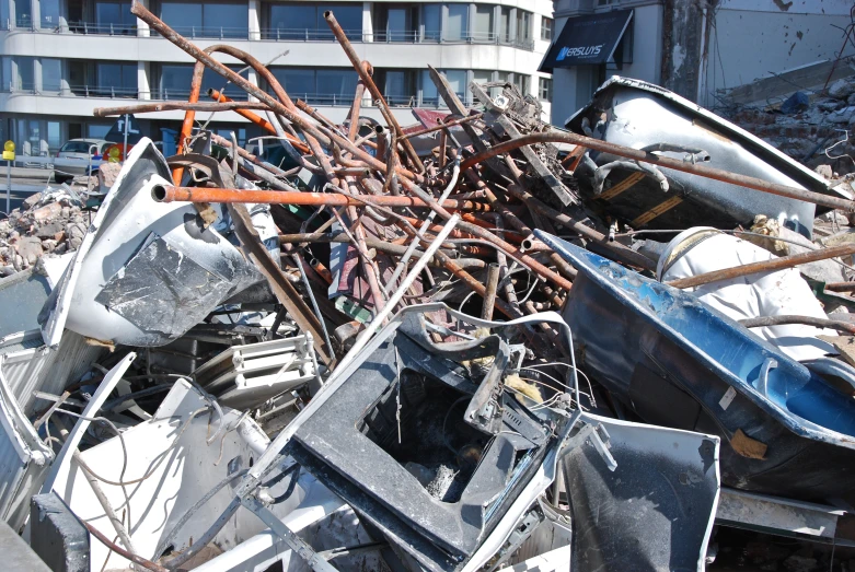 a pile of metal scrap in front of a tall building