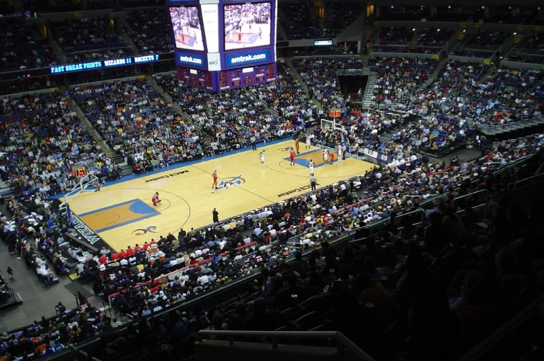 view of an arena with people at night, including people watching the action