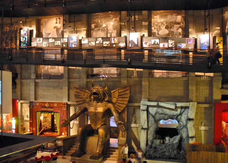 people walking in and out of a building with a statue