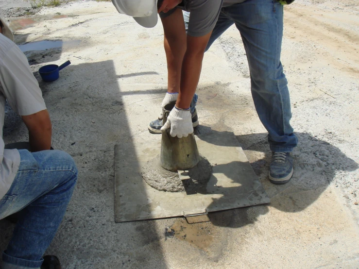 two men are working on cement work on the road