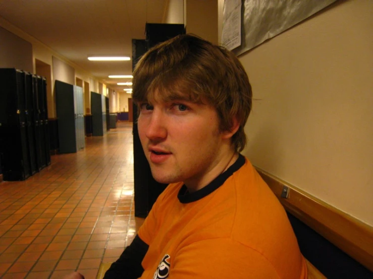 a man in a hallway next to many lockers