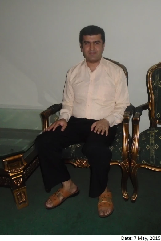 a man sitting on a chair with an old gold finish