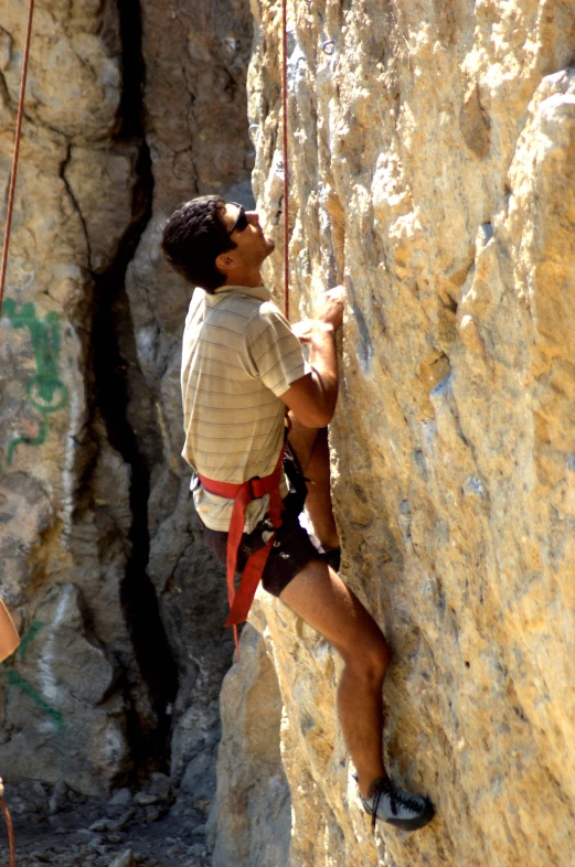 a man that is on a rock near a rope