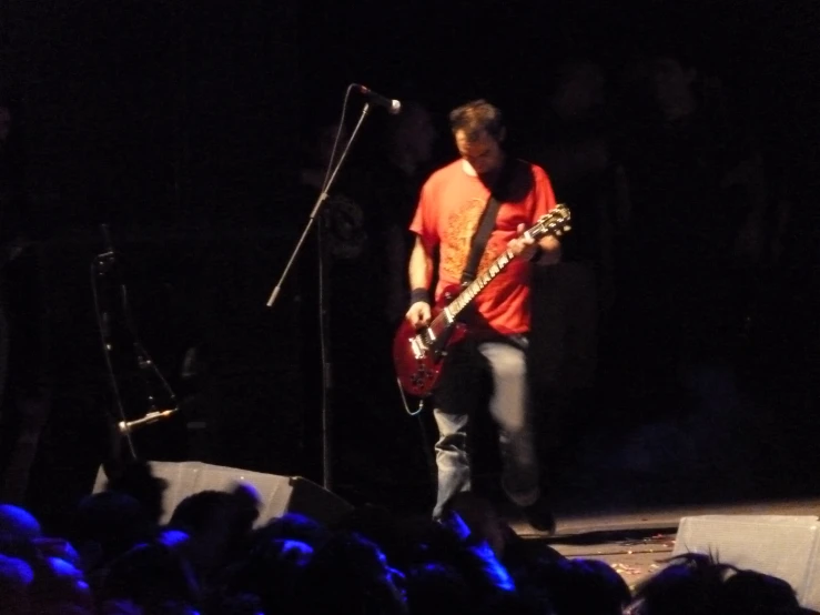 a person playing an electric guitar in front of a large crowd