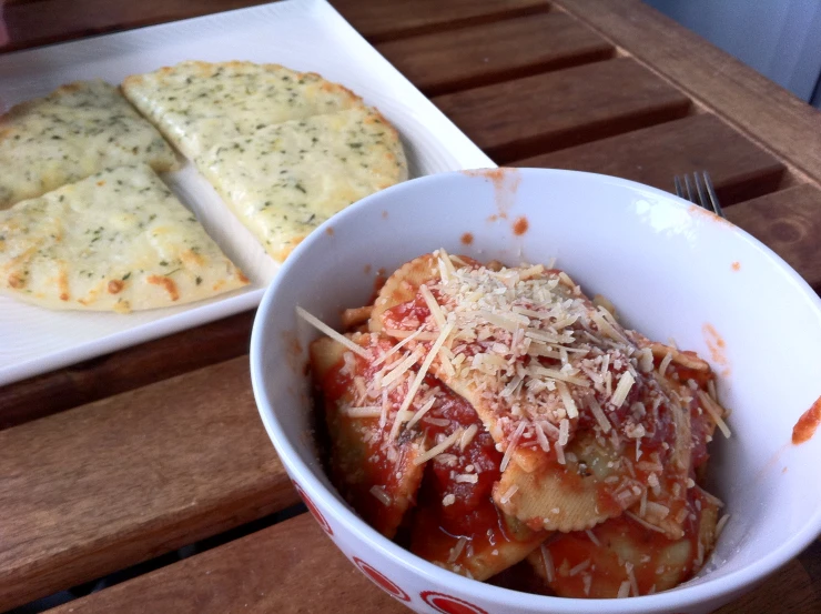 a white bowl filled with food on top of a wooden table